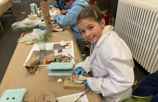 Een Kina Kid aan het knutselen tijdens een doe-workshop